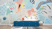 Playful abstract wall mural with colorful brushstrokes, dotted patterns, and modern art elements in a bedroom setting.