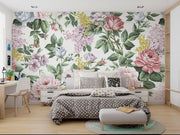 Elegant vintage floral wall mural with pink roses, lilacs, and greenery decorating a bedroom.