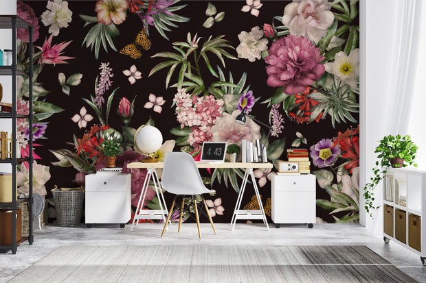 Romantic floral mural behind a modern white desk and tropical houseplants in a home office.