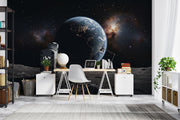 Wall mural of an astronaut sitting on the moon, gazing back at the Earth.