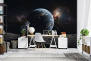Wall mural of an astronaut sitting on the moon, gazing back at the Earth.