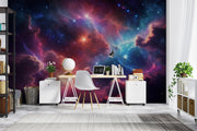 Celestial nebula wall mural featuring vibrant clouds of cosmic gas in blues, purples, and reds with glowing stars, styled in a modern bedroom.