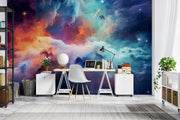 Celestial Dreams galaxy wall mural with colorful nebula clouds in orange, blue, and purple tones, styled in a home office.