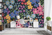 Colorful floral wall mural with hand-painted flowers in shades of blue, pink, yellow, and purple, displayed in a modern home office.
