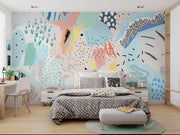Playful abstract wall mural with colorful brushstrokes, dotted patterns, and modern art elements in a bedroom setting.