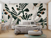 Lush foliage wall mural with bold green, beige, and rust botanical patterns and abstract dotted accents.