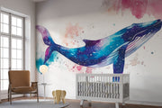Vibrant galaxy whale wall mural featuring a watercolor-style blue whale swimming through a cosmic, star-filled background in shades of blue, purple, and pink – perfect for kids' rooms and modern decor.