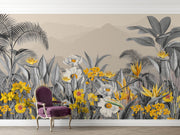 Modern tropical botanical wall mural with grayscale jungle leaves, vibrant yellow flowers, and a misty mountain backdrop in a cozy bedroom setting.