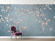 Cherry blossom wall mural with white flowers on twisting branches set against a rich blue background, creating a peaceful and stylish interior decor.
