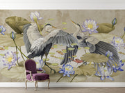 A sophisticated living room featuring a Heron & Lotus Pond Wall Mural with elegant birds in mid-flight, soft-toned lotus flowers, and floating lily pads. A neutral-colored  wooden armchair, and decorative accents complete the serene, nature-inspired ambiance.