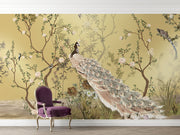 Golden Bloom wall mural with a cream peacock, flowering tree branches, and birds on a golden background in an elegant, Chinoiserie-style interior.