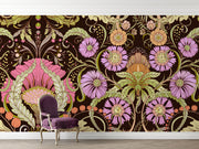 Opulent bloom wall mural with intricate lilac, peach, and green flowers on a dark background in a baroque vintage style, styled with a velvet chair.