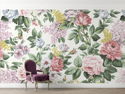 Elegant vintage floral wall mural with pink roses, lilacs, and greenery decorating a cozy, light-filled living room.
