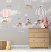 Whimsical hot air balloon animal wall mural featuring giraffes, pandas, elephants, and bears floating in the sky with soft pastel clouds – perfect for kid's rooms and nurseries.
