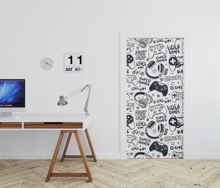 Black-and-white gaming-themed door mural featuring video game controllers, gamer doodles, and phrases like "Level Up!" and "Just Play!"