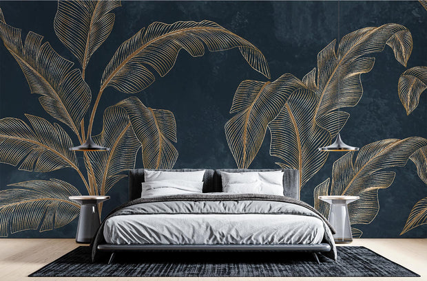 Golden banana leaf wall mural with metallic leaves on a deep black background, styled in a modern bedroom with a sleek bed and pendant lights
