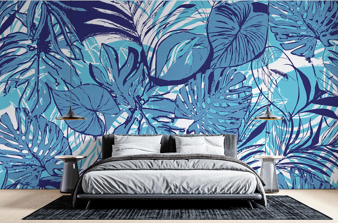 Tropical blue leaf wall mural featuring bold illustrations of large leaves in vibrant aqua and navy tones, decorating a modern bedroom with sleek furniture and cozy bedding.