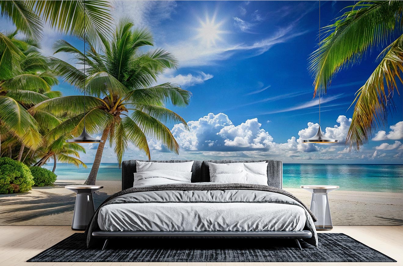 Tropical beach wall mural with palm trees, a sunny sky, turquoise ocean waters and white sandy beach, styled in a modern bedroom with a cozy bed.