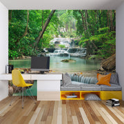 Wall mural of a lush green forest with cascading waterfalls, creating a peaceful ambiance in a modern room.
