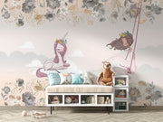 A whimsical nursery wall mural featuring a pink unicorn resting on clouds, a girl swinging with floral details, and soft pastel tones for a dreamy ambiance.