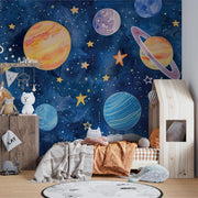 Hand-painted watercolor-style wall mural of planets, stars, and a dreamy blue galaxy, ideal for decorating kids’ bedrooms or playrooms.