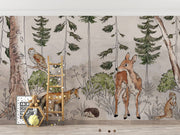 A charming woodland wall mural featuring a deer, fox, owl, and lush greenery surrounded by tall trees. Perfect for kid's rooms or nature-themed nurseries.