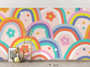 Kids wall mural with retro-style rainbow arches and colorful flowers in a playful, children's playroom.
