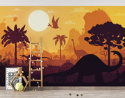 Kids’ dinosaur wall mural featuring silhouettes of Brachiosaurus, Pterosaurs, and prehistoric trees against an orange sunset, ideal for a playful bedroom or playroom.