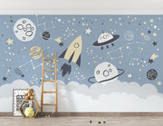 Space-themed wall mural with rocket, UFOs, planets, and constellations on a blue sky background—ideal for kids' room décor.