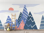 Adventure Peaks wall mural featuring abstract mountain shapes in blue and peach tones with a sun and clouds, styled in a boy’s bedroom.