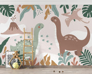 Kids’ wall mural with cartoon dinosaurs, volcano, pterodactyl, and tropical leaves in soft earth tones; styled in a cozy children’s playroom.