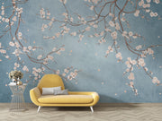 Cherry blossom wall mural with white flowers on twisting branches set against a rich blue background, creating a peaceful and stylish interior decor.