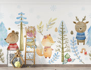 Winter woodland animal wall mural featuring a bear, fox, deer, and owl in cozy knitted sweaters, surrounded by snow-covered trees and soft blue foliage.