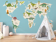 Dinosaur world map wall mural featuring illustrated dinosaurs on different continents, set against a blue background, perfect for kid's rooms and playrooms.