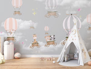 Whimsical hot air balloon animal wall mural featuring giraffes, pandas, elephants, and bears floating in the sky with soft pastel clouds – perfect for kid's rooms and nurseries.