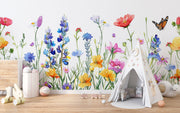 Watercolor wildflower wall mural featuring hand-painted flowers in vibrant colors with butterflies, styled in a playful children’s room with a white teepee.
