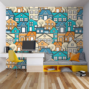 Colorful geometric house wall mural featuring vibrant blue, orange, and beige houses with minimalist trees, creating a modern and lively room atmosphere.