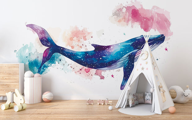 Vibrant galaxy whale wall mural featuring a watercolor-style blue whale swimming through a cosmic, star-filled background in shades of blue, purple, and pink – perfect for kids' rooms and modern decor.