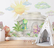 Pastel dinosaur wall mural with soft watercolor-style dinosaurs, a cozy stone cave, lush greenery, and a glowing sun, perfect for nurseries and playrooms.