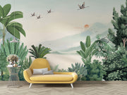 Scenic jungle wall mural with green tropical leaves, misty mountains, and flying cranes against a soft sunrise backdrop.