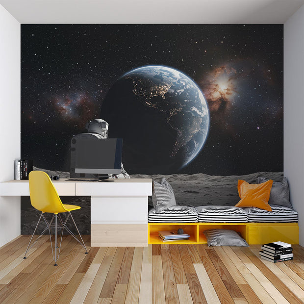 Wall mural of an astronaut sitting on the moon, gazing back at the Earth.