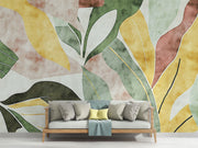 Abstract watercolor leaf wall mural with earthy green, yellow, and terracotta tones in a modern botanical design.