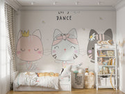 Adorable cat ballerina mural in soft pastel colors, showing three dancing cats in tutus with the phrase "Let's Dance" above them, decorating a children’s room.