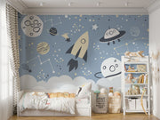 Space-themed wall mural with rocket, UFOs, planets, and constellations on a blue sky background—ideal for kids' room décor.