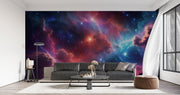 Celestial nebula wall mural featuring vibrant clouds of cosmic gas in blues, purples, and reds with glowing stars, styled in a modern living room.