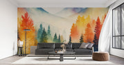 Watercolor mountain landscape wall mural with autumn forest in orange, yellow and teal, styled in modern living room.