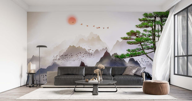 Minimalist Japanese mountain landscape wall mural with coral sunset and flying birds, styled in modern living room with grey sofa.
