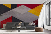 Modern geometric wall mural with an urban brick texture featuring bold abstract shapes in red, yellow, black, and gray. Ideal for industrial-style living rooms, lofts, and offices.