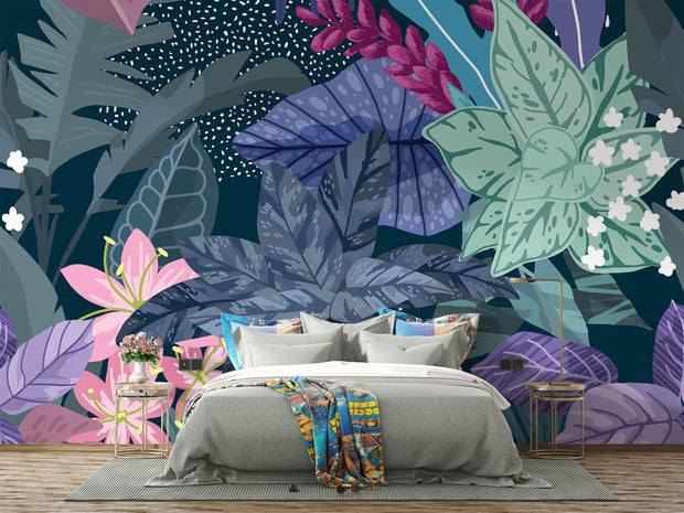 Illustrated tropical botanical wall mural with large jungle leaves, pink lilies, white flowers, and deep blue background, styled in a modern bedroom.