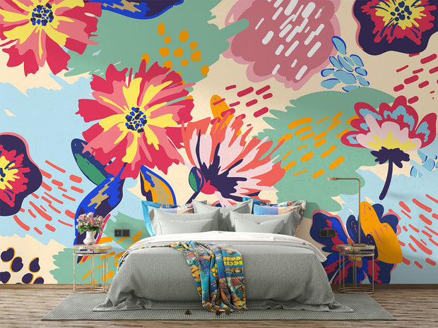 Vibrant floral wall mural with bold, hand-painted flowers in red, yellow, blue, and green, displayed in a modern bedroom setting.